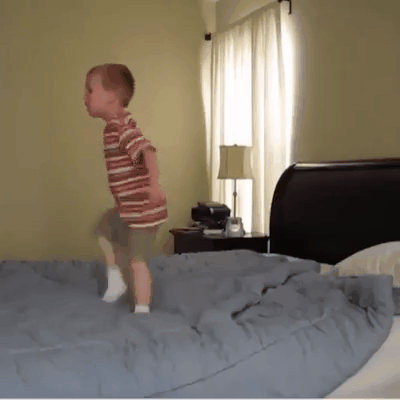 The child is trying to catch a pillow
