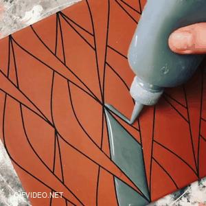 Hand painting a ceramic tile